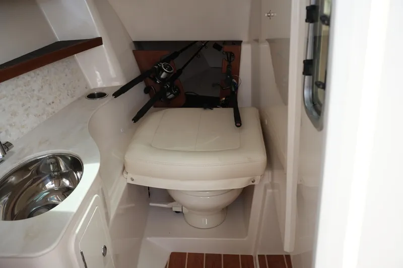 Slide: The Image of 2018 Grady-White Freedom 325 boat interior with sink, toilet, and fishing rods. - 46