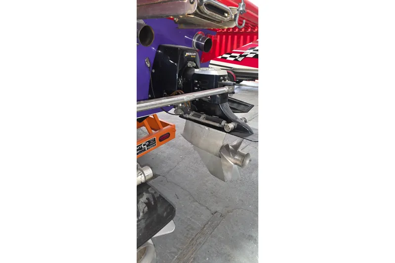 Slide: The Image of 2003 Cigarette 38' Top Gun boat engine and propeller detail in a garage setting. - 25