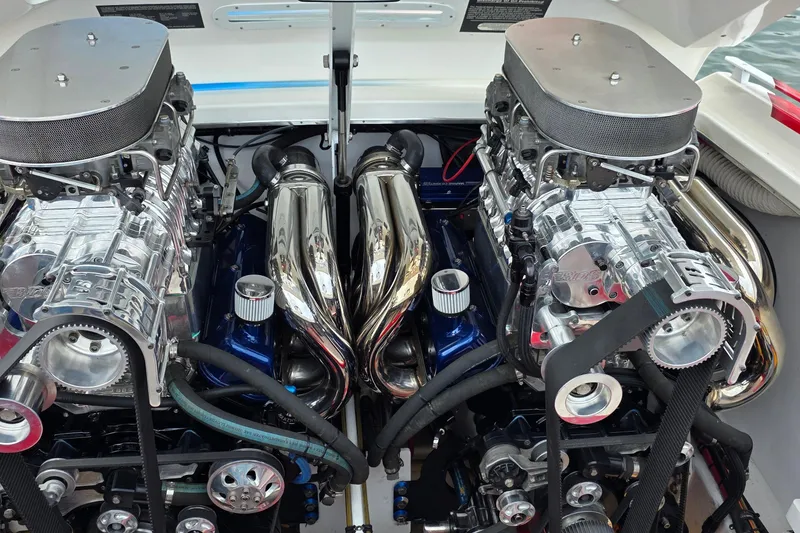 Slide: The Image of Twin engines of a 2003 Cigarette 38' Top Gun boat, showcasing chrome and mechanical details. - 8