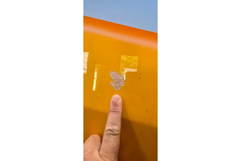 Slide: The Image of Close-up of a 2003 Cigarette 38' Top Gun boat with a finger pointing at a scratch. - 29