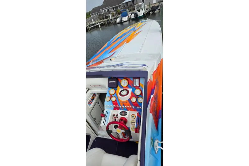 Slide: The Image of 2003 Cigarette 38' Top Gun boat with vibrant dashboard and colorful exterior design. - 6