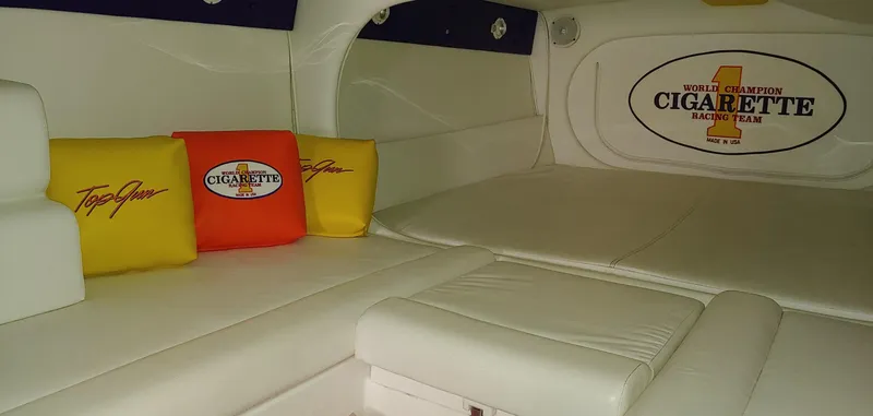 Slide: The Image of Interior of a 2003 Cigarette 38' Top Gun boat with white upholstery and colorful cushions. - 21