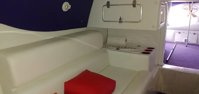 Slide: The Image of The image shows the interior of a 2003 Cigarette 38' Top Gun boat with white seating and red cushions. - 19