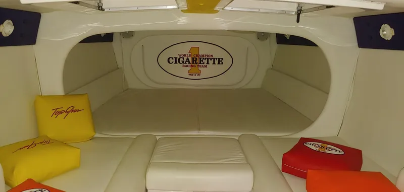 Slide: The Image of Interior of a 2003 Cigarette 38' Top Gun with cushioned seating and colorful pillows. - 16