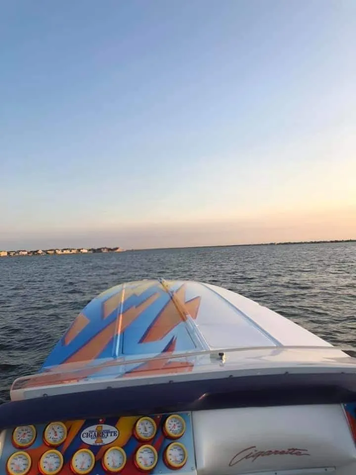 Slide: The Image of A 2003 Cigarette 38' Top Gun on the water at sunset. - 5