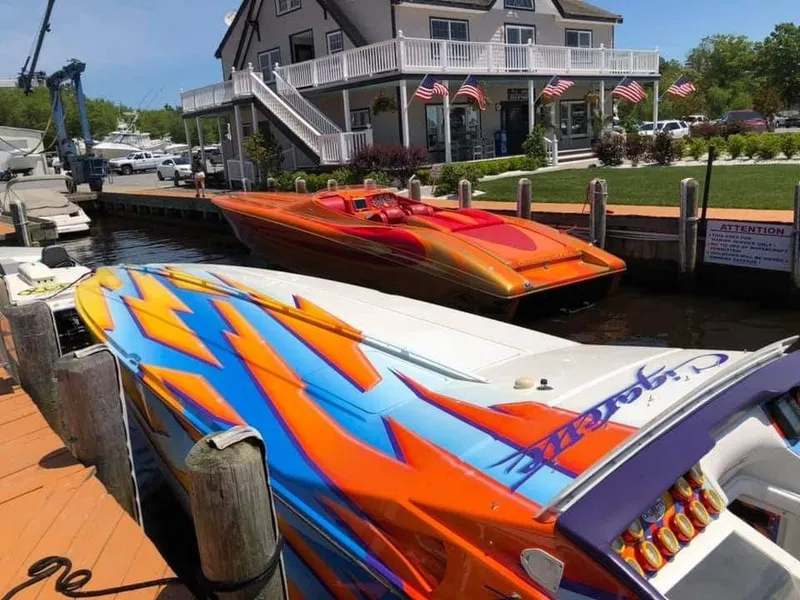 Slide: The Image of Two colorful speedboats docked near a building with American flags displayed. - 4