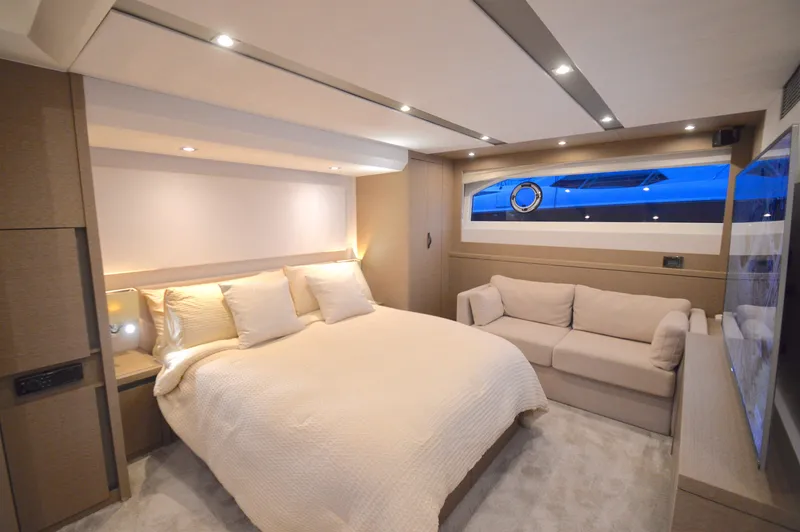 Slide: The Image of Luxurious cabin with a large bed, sofa, and a porthole letting in blue light. - 2