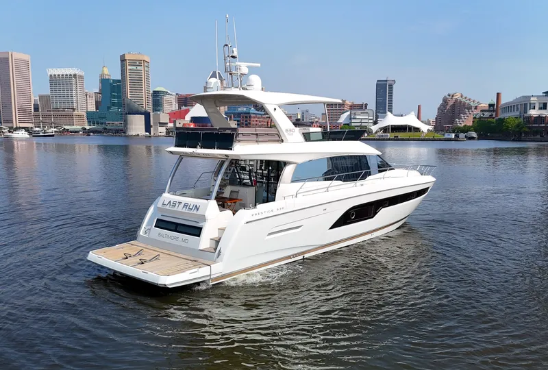 The Image of A luxury motor yacht cruises on calm waters with a city skyline in the background. - 5