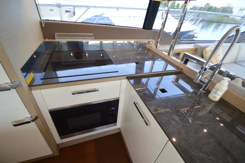 Slide: The Image of Modern yacht kitchen with dark countertops, sink, and microwave, surrounded by windows. - 15