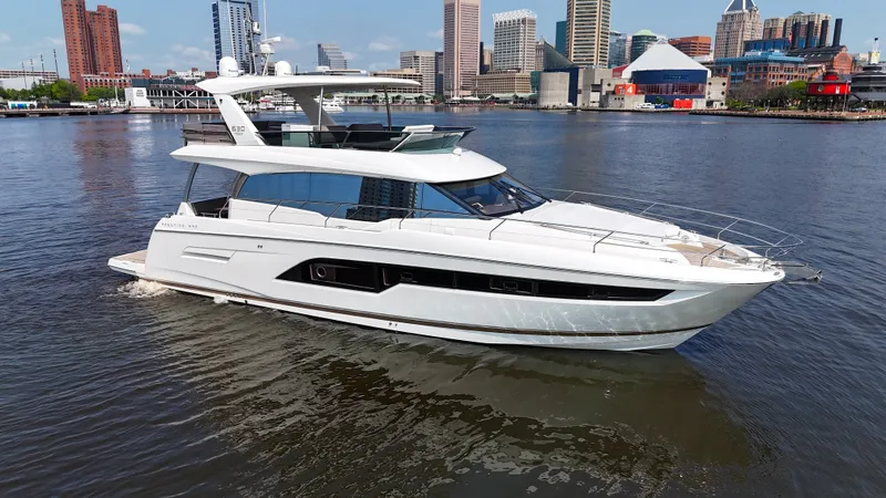 Slide: The Image of A luxurious white yacht cruising on calm waters with a cityscape in the background. - 0