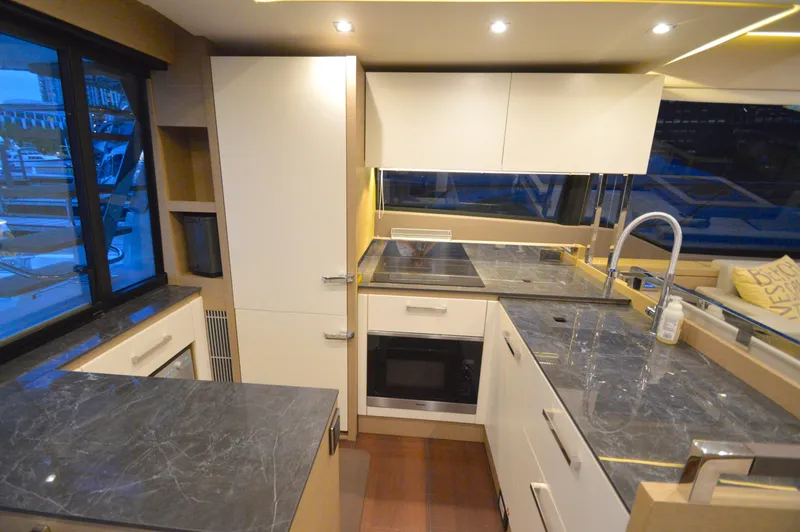 Slide: The Image of The kitchen of a 2017 Prestige 630 yacht with modern appliances and marble countertops. - 23