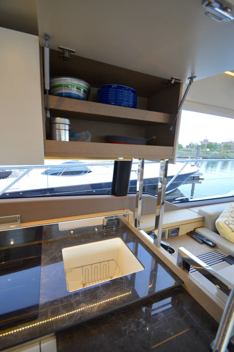 Slide: The Image of The 2017 Prestige 630 kitchen features a sleek countertop and a view of the marina. - 19
