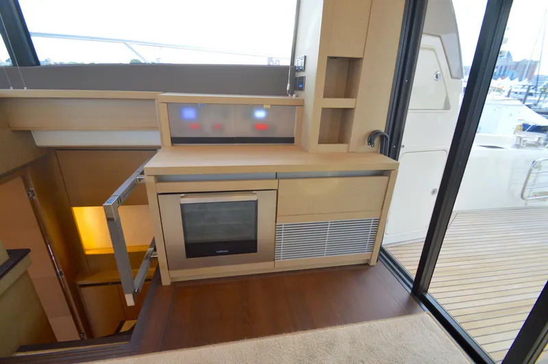 Slide: The Image of The 2017 Prestige 630 features a modern kitchen with an oven and storage, adjacent to the deck. - 24