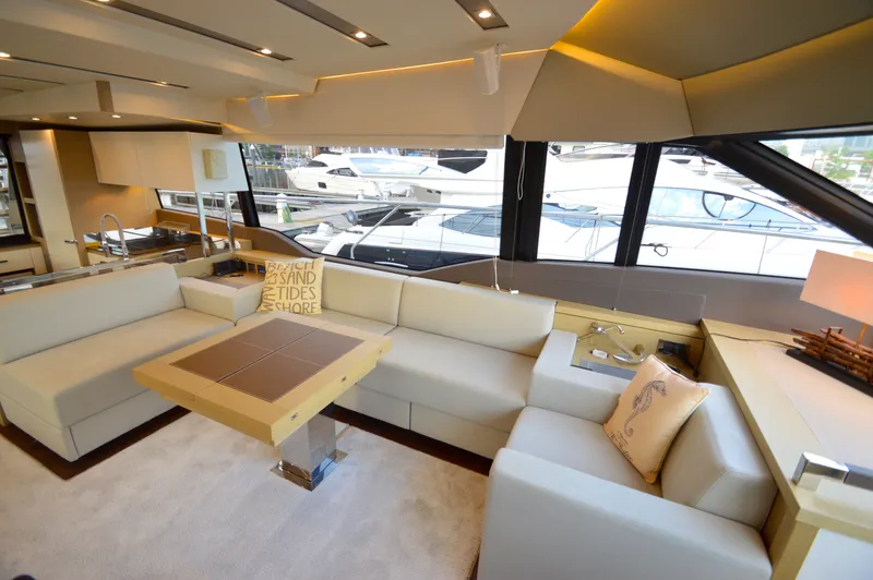 Slide: The Image of The luxurious interior of a 2017 Prestige 630 yacht with elegant sofas and large windows. - 29