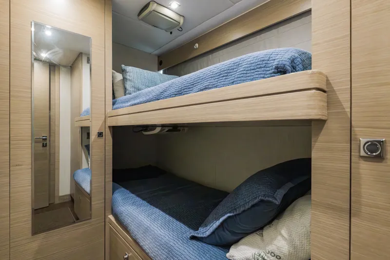 Slide: The Image of Bunk beds in 2016 Hargrave Flybridge Motor Yacht cabin with blue bedding and wood finish. - 80