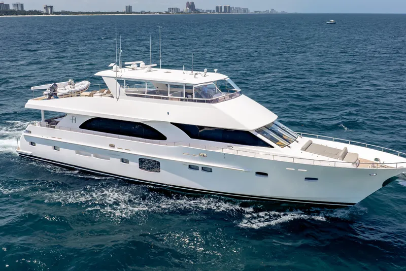 Slide: The Image of 2016 Hargrave Flybridge Motor Yacht cruising on open water, city skyline in background. - 90
