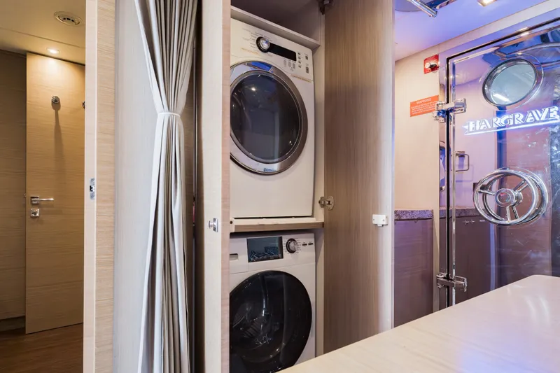 Slide: The Image of Laundry area inside 2016 Hargrave Flybridge Motor Yacht with stacked washer and dryer. - 76