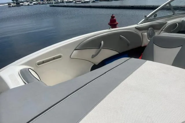 Slide: The Image of 2011 Bayliner 185 Bowrider interior with gray seating, docked by the water. - 8