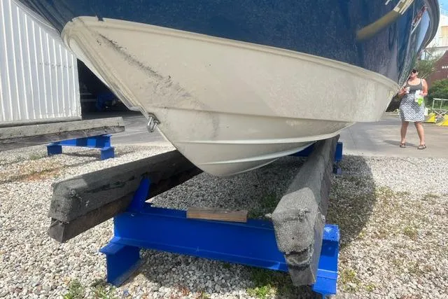 Slide: The Image of 2011 Bayliner 185 Bowrider on blue supports, displayed outdoors on gravel. - 4