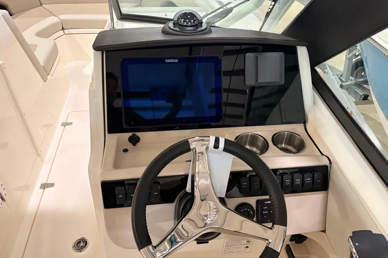 Slide: The Image of 2026 Boston Whaler 240 Vantage dashboard with steering wheel and navigation display. - 15