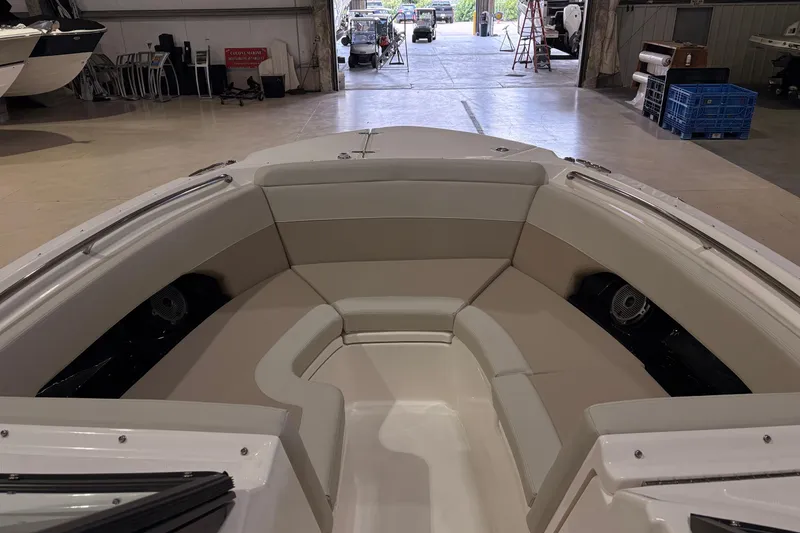 Slide: The Image of 2026 Boston Whaler 240 Vantage boat interior with beige seating in a spacious garage. - 18