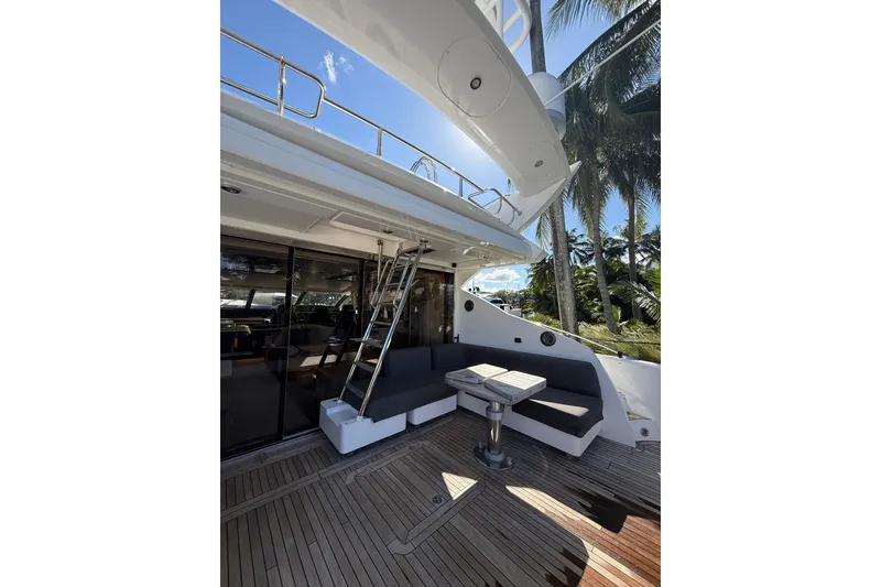 Slide: The Image of 2012 Sunseeker Predator Sport Yacht 74, outdoor seating area with table and ladder. - 10