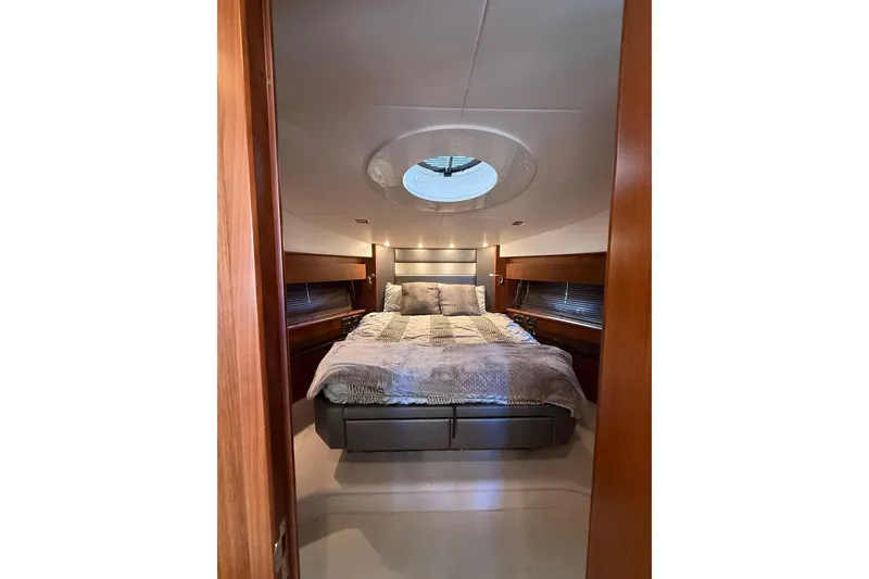 Slide: The Image of Luxurious bedroom interior of 2012 Sunseeker Predator Sport Yacht 74, featuring elegant bedding and wood accents. - 26