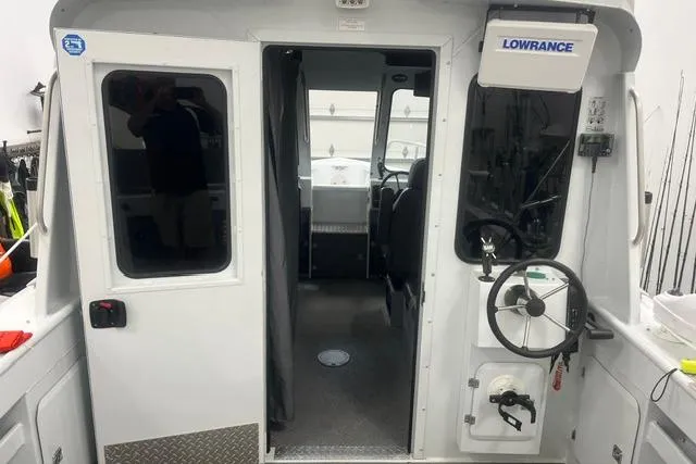 Slide: The Image of 2020 Hewescraft 240 Ocean Pro boat interior with steering wheel and navigation equipment. - 9