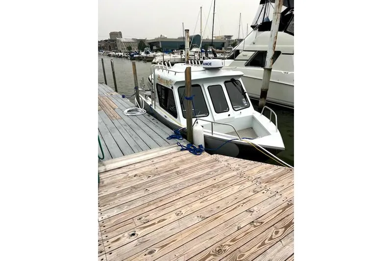 Slide: The Image of 2020 Hewescraft 240 Ocean Pro docked at a marina, surrounded by other boats. - 24