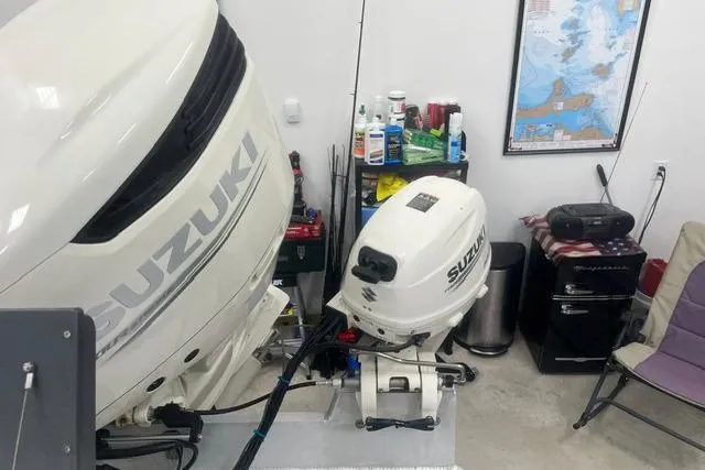 Slide: The Image of Two Suzuki outboard motors in a garage, with a map and maintenance supplies nearby. - 21
