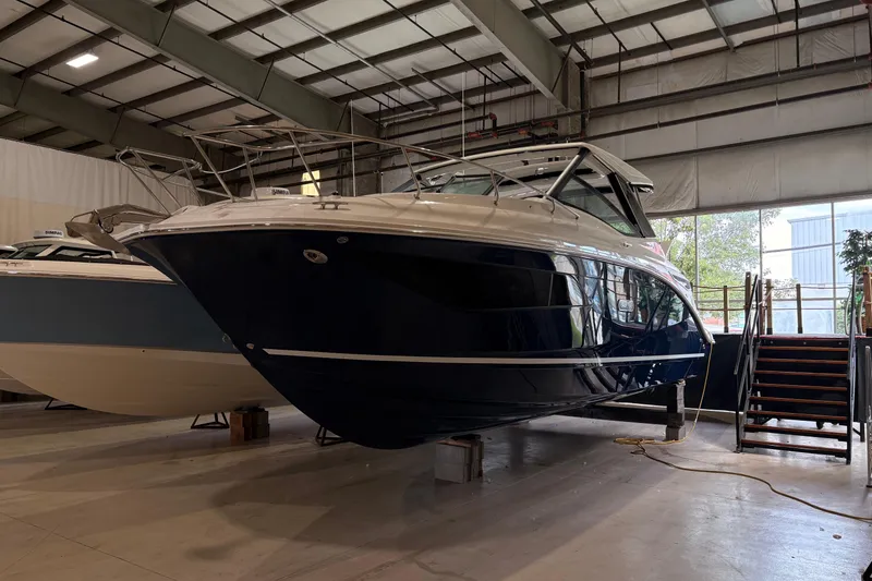 The Image of 2027 Sea Ray Sundancer 320 yacht in a spacious indoor storage facility. - 1