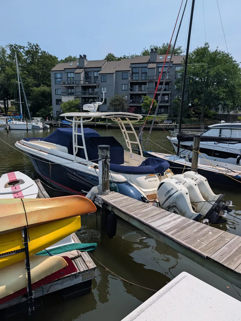 Slide: The Image of A 2016 Chris-Craft 36 Launch is docked. Several boats and kayaks are nearby. - 13