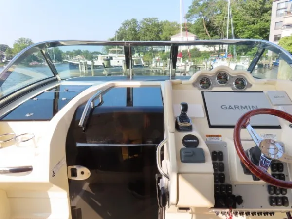 Slide: The Image of The cockpit of a 2016 Chris-Craft 36 Launch with Garmin navigation and a wooden steering wheel. - 14