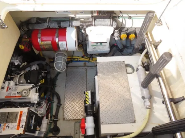 Slide: The Image of The engine compartment of a 2016 Chris-Craft 36 Launch shows engines, fire extinguisher, and technical equipment. - 21