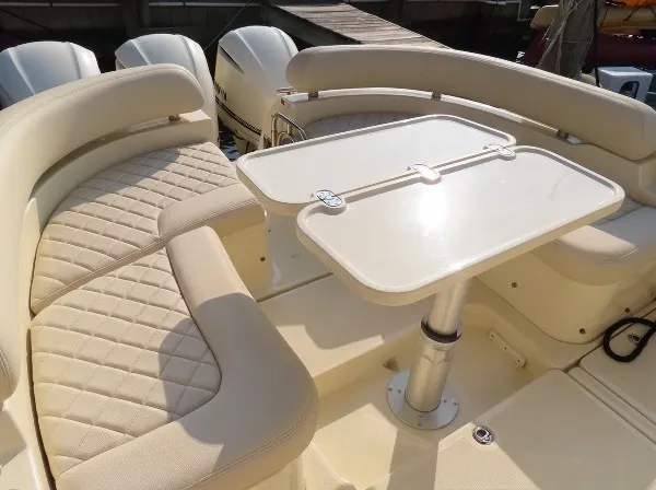 Slide: The Image of The image shows the seating area of a 2016 Chris-Craft 36 Launch boat with a table. - 18