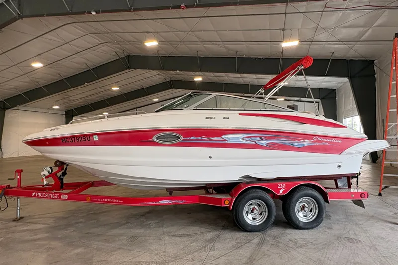 The Image of 2005 Crownline 220 EX boat on red trailer in indoor storage facility. - 0