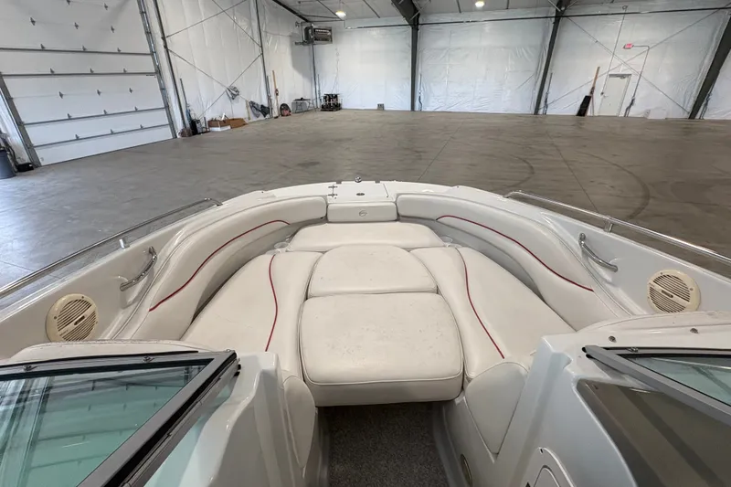 Slide: The Image of 2005 Crownline 220 EX boat interior with white seating in a spacious warehouse. - 17