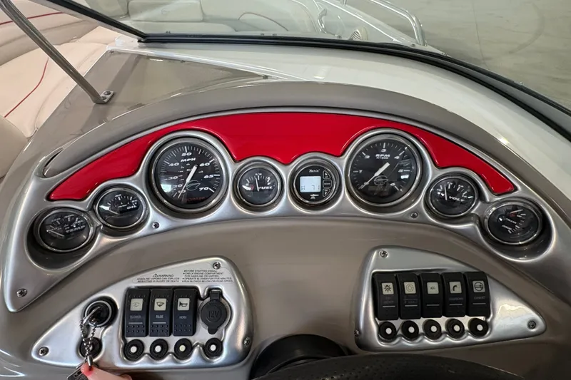Slide: The Image of Dashboard of a 2005 Crownline 220 EX boat with gauges and control switches. - 13