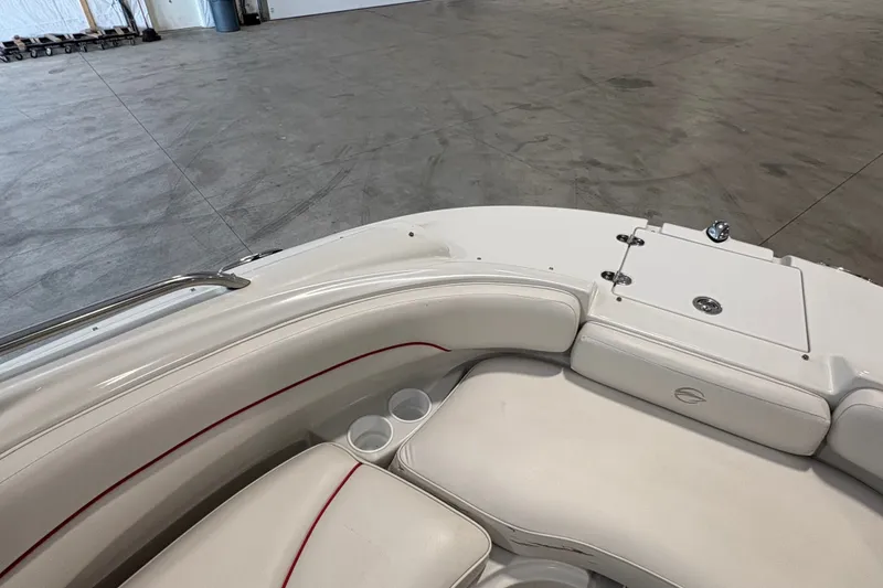 Slide: The Image of 2005 Crownline 220 EX boat interior with white seating and cup holders in a spacious area. - 18