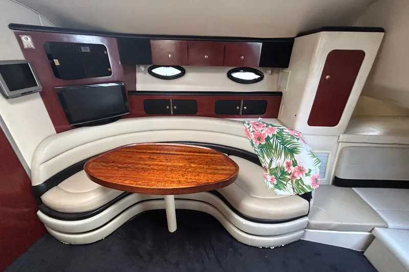 Slide: The Image of Interior of 2001 Wellcraft 3700 Martinique yacht with curved seating and wooden table. - 21