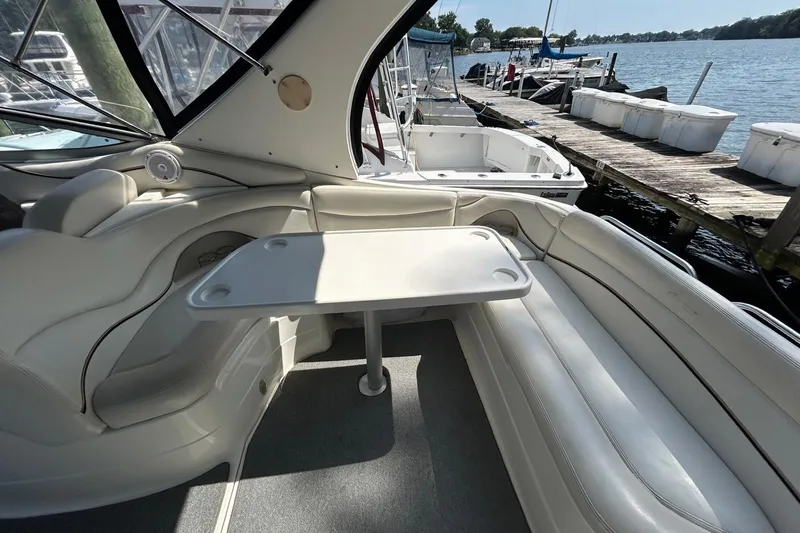 Slide: The Image of 2001 Wellcraft 3700 Martinique boat interior with seating and table by the dock. - 11