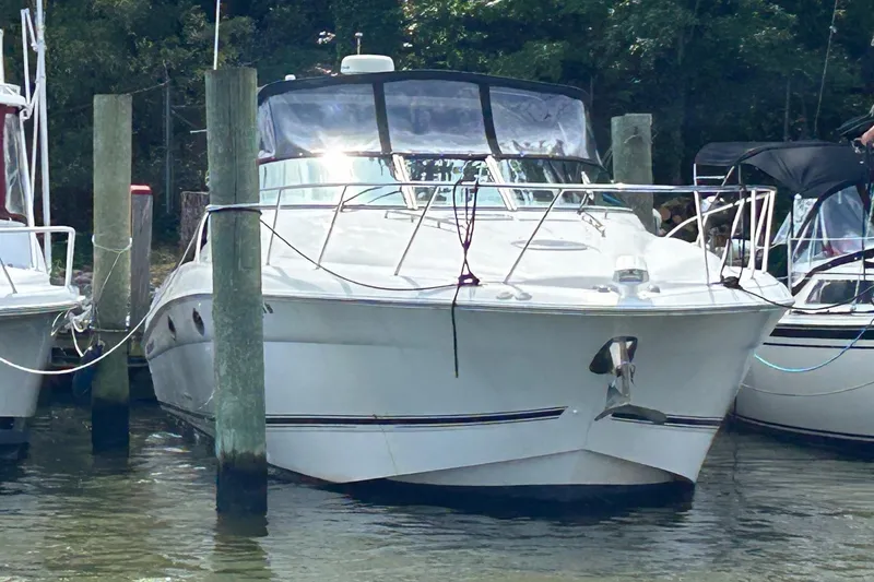 Slide: The Image of 2001 Wellcraft 3700 Martinique boat docked at marina, surrounded by water and trees. - 5