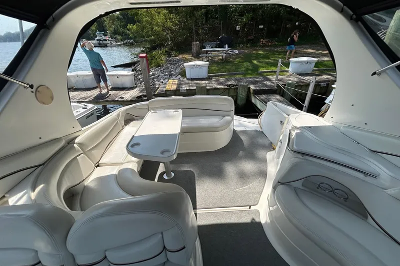 Slide: The Image of 2001 Wellcraft 3700 Martinique boat interior with white seating and table, dockside view. - 19