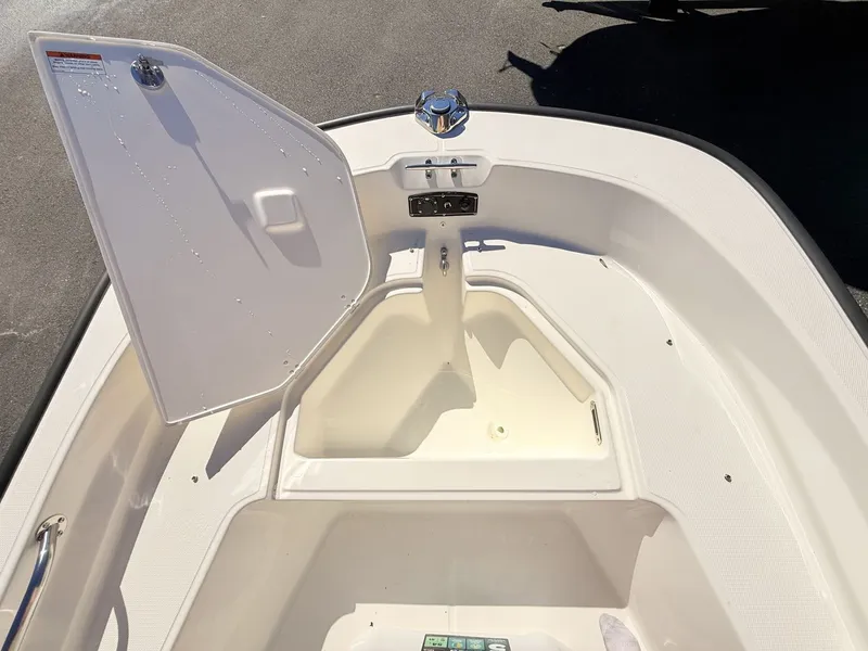 Slide: The Image of The image shows the bow area of a 2027 Boston Whaler 150 Montauk with an open storage compartment. - 35