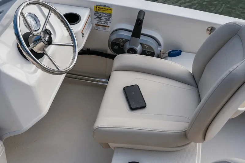 Slide: The Image of The image shows the cockpit of a Boston Whaler 150 Montauk with a steering wheel and seat. - 49