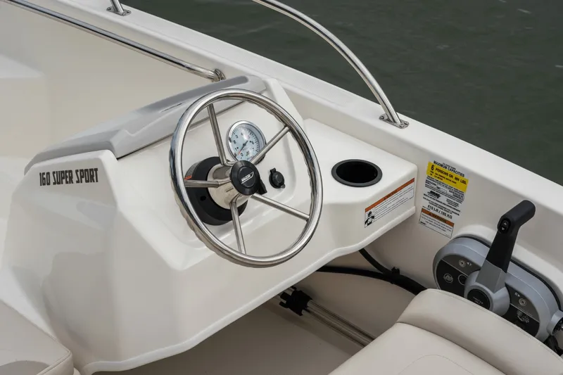 Slide: The Image of The image shows the helm of a 2027 Boston Whaler 150 Montauk with a stainless steel wheel. - 42