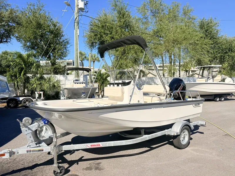 Slide: The Image of A 2027 Boston Whaler 150 Montauk on a trailer. It features a black Bimini top. - 8