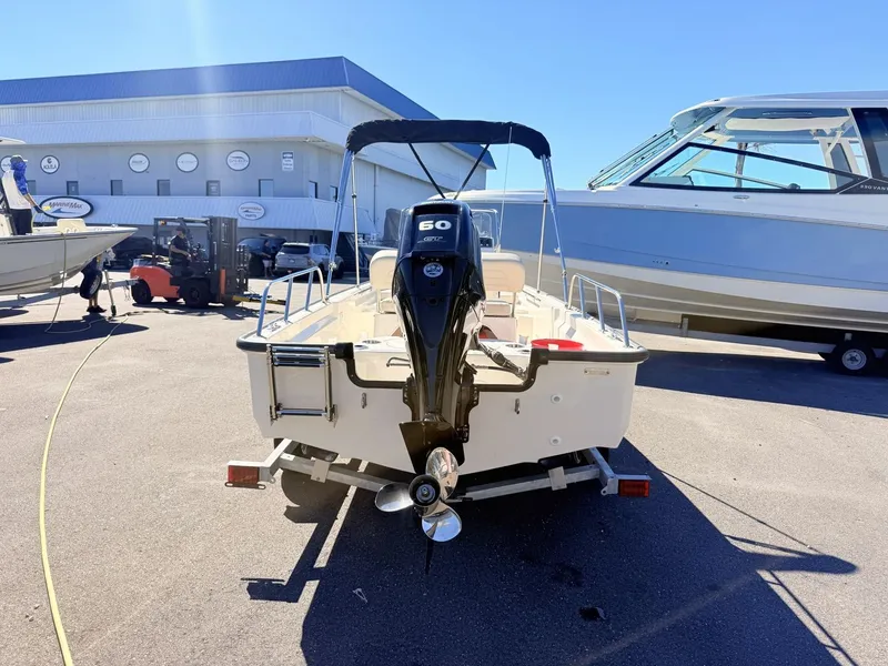 Slide: The Image of A 2027 Boston Whaler 150 Montauk with a 60 HP engine, parked on a trailer. - 5
