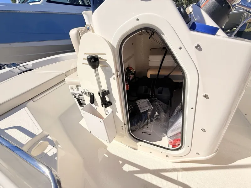 Slide: The Image of The image shows the interior of a 2027 Boston Whaler 150 Montauk with storage and helm console. - 26