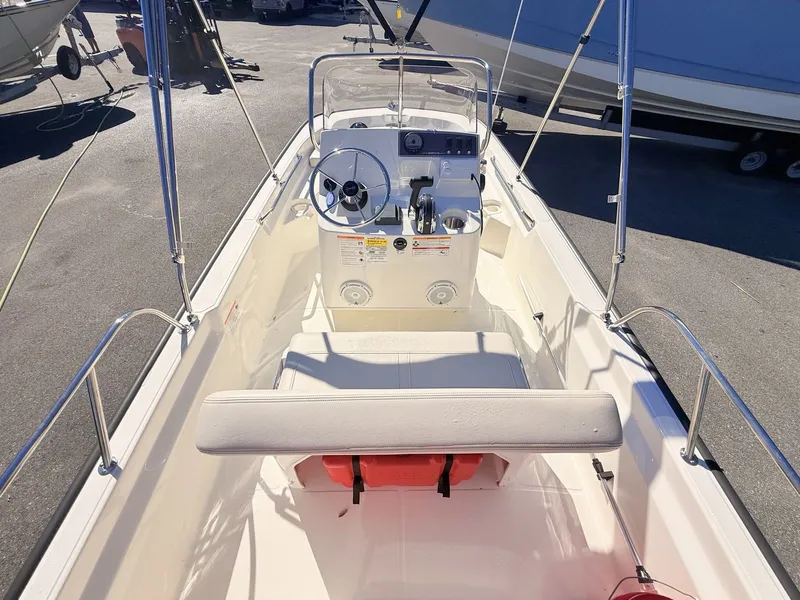 Slide: The Image of The image shows the cockpit of a 2027 Boston Whaler 150 Montauk with a helm and bench seat. - 18